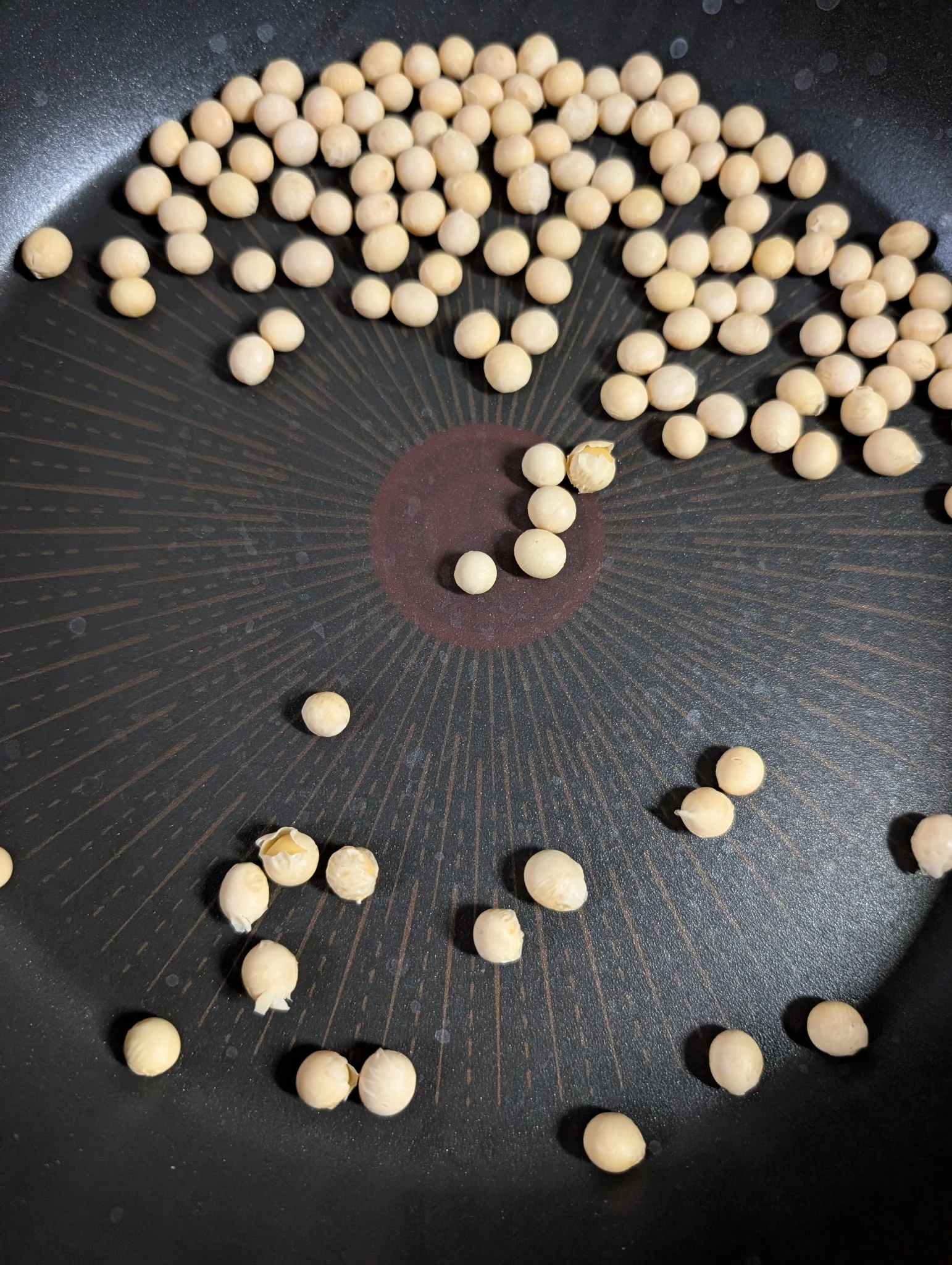 Dry soybeans roasting in a pan for Japanese soybean dashi
